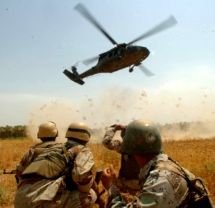 US Navy 060816-N-4097B-023 Iraqi army soldiers from 3rd Battalion, 3rd Brigade, 5th Iraqi Army Division brace themselves as a helicopter approaches to pick them up following a local engagement visit