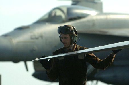 US Navy 060824-N-8604L-076 A Carrier Air Wing Five (CVW-5) Plane Captain conducts a rivet inspection on the wing an F-A-18 Hornet prior to flight operation on the flight deck of USS Kitty Hawk (CV 63)