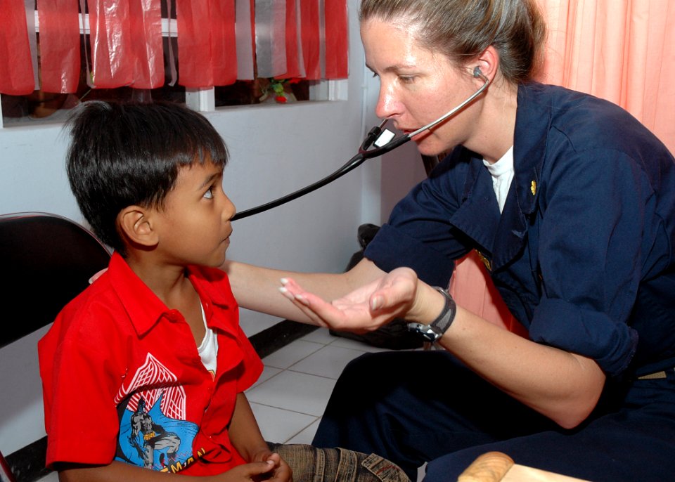 US Navy 060821-N-3931M-092 Navy Lt. Cmdr. Elizabeth Ferrara with the Medical Treatment Facility aboard the Military Sealift Command hospital ship USNS Mercy (T-AH 19) examines the breathing of a young boy