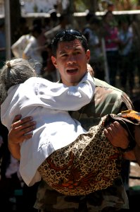 US Navy 060824-N-9076B-229 Navy Petty Officer 2nd Class Michael Orta of Los Angeles, carries a woman to the medical outreach facility at the Batakte Health Center