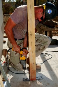 US Navy 060815-N-8623S-019 A Seabee assigned to Naval Mobile Construction Battalion Four Zero (NMCB-40) works to secure the support beam of a generator shelter outside the command's headquarters