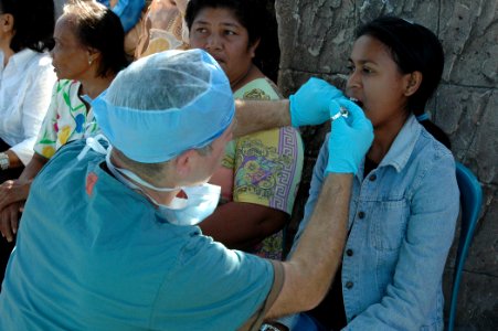 US Navy 060822-N-1577S-022 Air Force Lt. Col. Gary Leake prepares to remove a tooth from a patient at a medical and dental civic action project