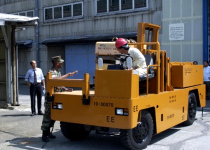 US Navy 060827-N-6959H-001 Construction Mechanic 1st Class Paul Fennell from U.S. Fleet and Industrial Supply Center (FISC) Yokosuka gives instructions to a Japanese forklift driver