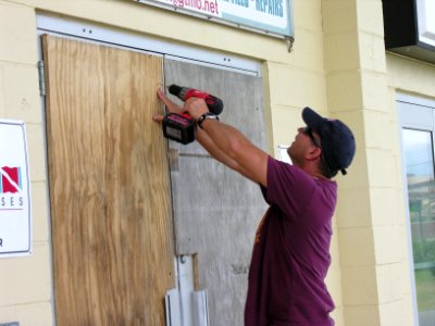 US Navy 060827-N-9449W-001 Master-at-Arms 1st Class James Blagg helps board up the doors of the base dive shop on board U.S. Naval Station Guantanamo Bay, Cuba, during preparations for Hurricane Ernesto