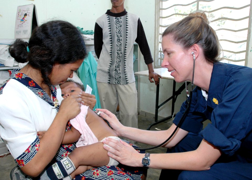 US Navy 060827-N-9076B-113 Navy Lt. Cmdr. Elizabeth Ferrara, assigned to the Medical Treatment Facility aboard the Military Sealift Command hospital ship USNS Mercy (T-AH 19), listens to a child's heartbeat on the first
