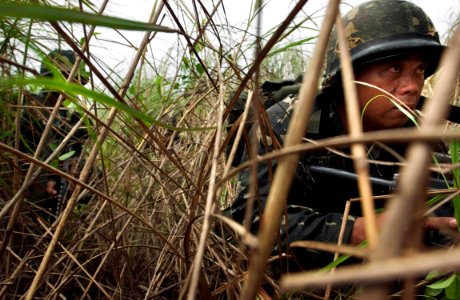 US Navy 060818-N-9851B-006 A Philippine Marine maneuvers through tall grass as he makes his way to his objective during an exercise Cooperation Afloat Readiness and Training (CARAT) amphibious assault from dock landing ship USS