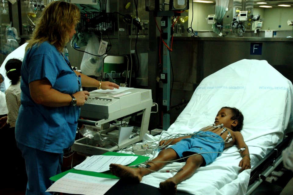 US Navy 060829-N-1577S-056 Aloha Medical Mission volunteer Patti Aylward embarked with the Medical Treatment Facility aboard the Military Sealift Command hospital ship USNS Mercy (T-AH 19), administers an EKG on a patient