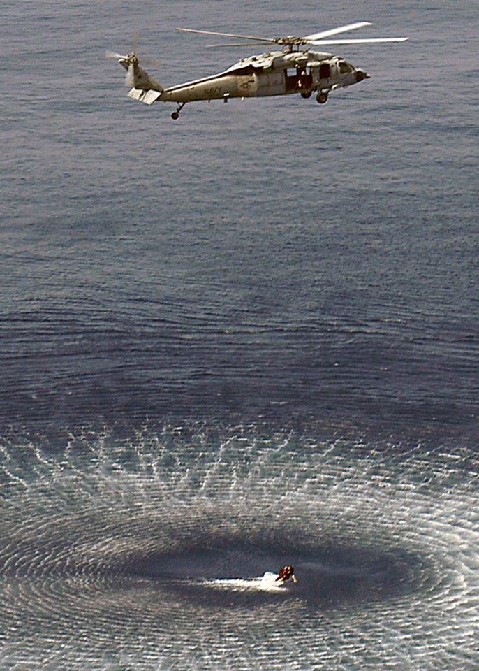 US Navy 060824-N-8547M-016 A search and rescue swimmer (SAR) is hoisted out of the water by an MH-60S Seahawk assigned to Helicopter Sea Combat Support Squadron Two Six (HSC-26), during combined training with SAR swimmers
