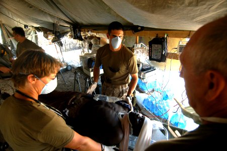 US Navy 060818-N-0411D-082 U.S. Navy Cmdr. Dr. Warren Gilbert, left, of Reno, Nev., examines a patient with a mock head during field training