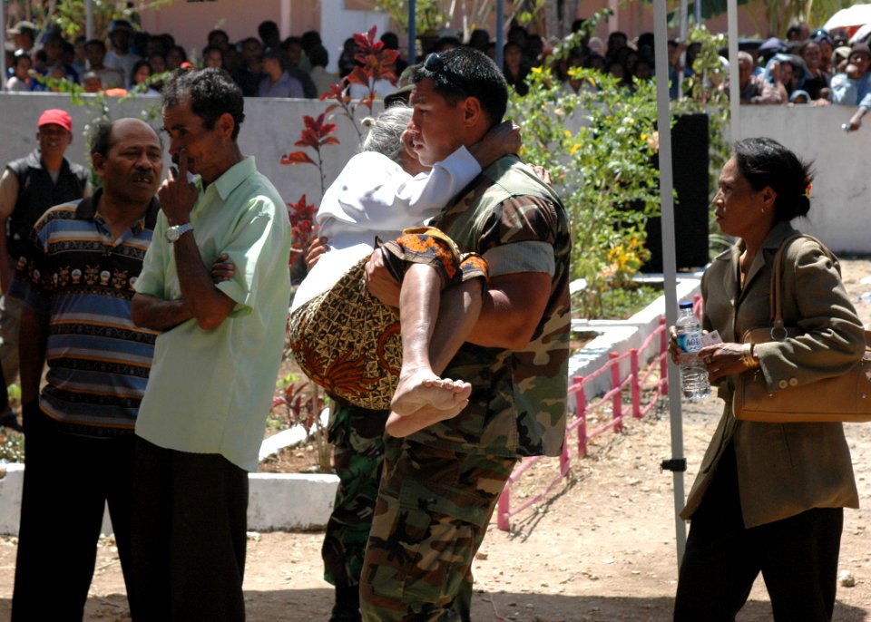 US Navy 060824-N-9076B-226 Navy Petty Officer 2nd Class Michael Orta of Los Angeles, carries a woman into the medical outreach at the Batakte Health Center