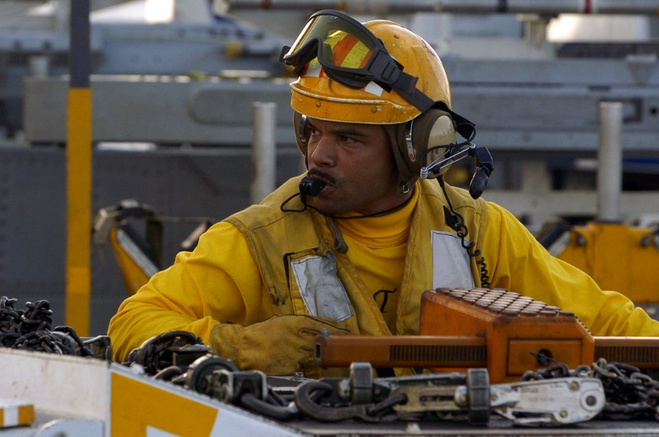 US Navy 060822-N-8604L-317 Chief Aviation Boatswain's Mate Handling Jimmy Candelaria prepares to direct an E-2C Hawkeye assigned to Carrier Airborne One One Five (VAW-115) during a no-fly day aboard the conventionally-powered a