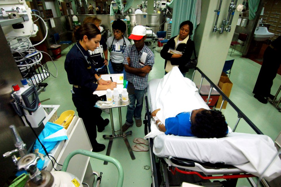 US Navy 060827-N-2832L-068 Navy Lt. Kimberly Williams, records patient data with the help of a translator aboard the Military Sealift Command hospital ship USNS Mercy (T-AH 19) in casualty receiving