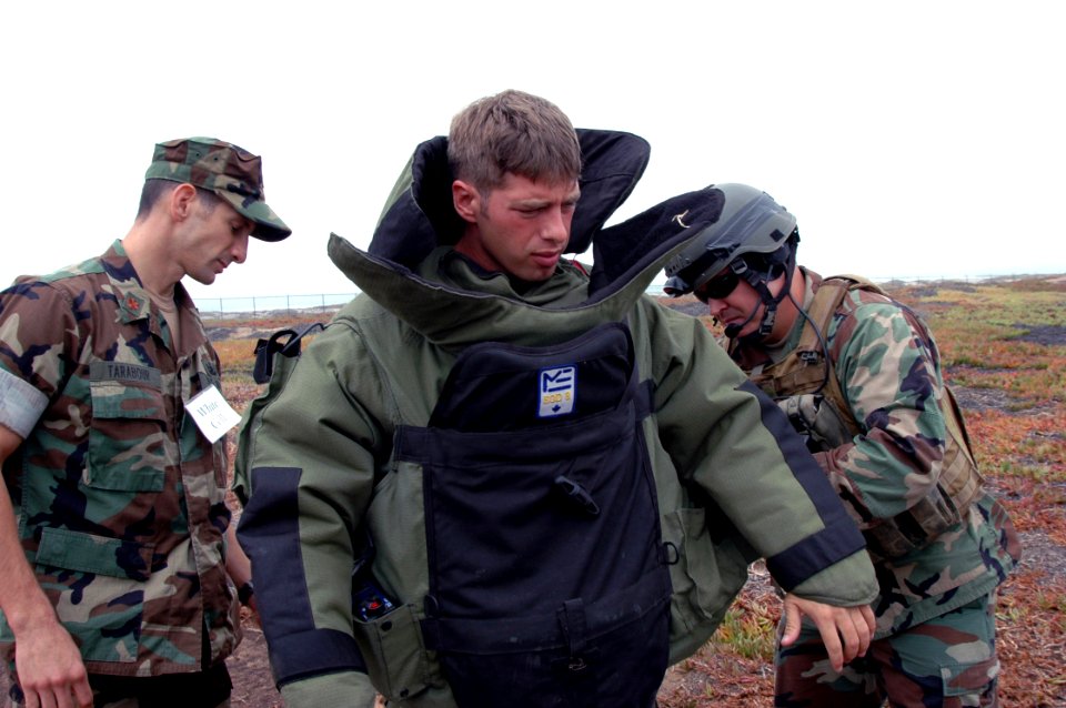 US Navy 060830-N-9195K-030 Explosive Ordinance Disposalman 2nd Class Thayer Jones, assigned to Naval Special Clearance Team One (NSCT-1), is helped by members of his team into a special suit used for explosive disposal, while p