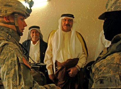 US Navy 060830-N-4097B-019 U.S. Army Lt. Alan Boyes, right, with Charlie Company, 1st Battalion, 68th Armored Regiment, 4th Infantry Division, talks to local Iraqi council members through an interpreter photo
