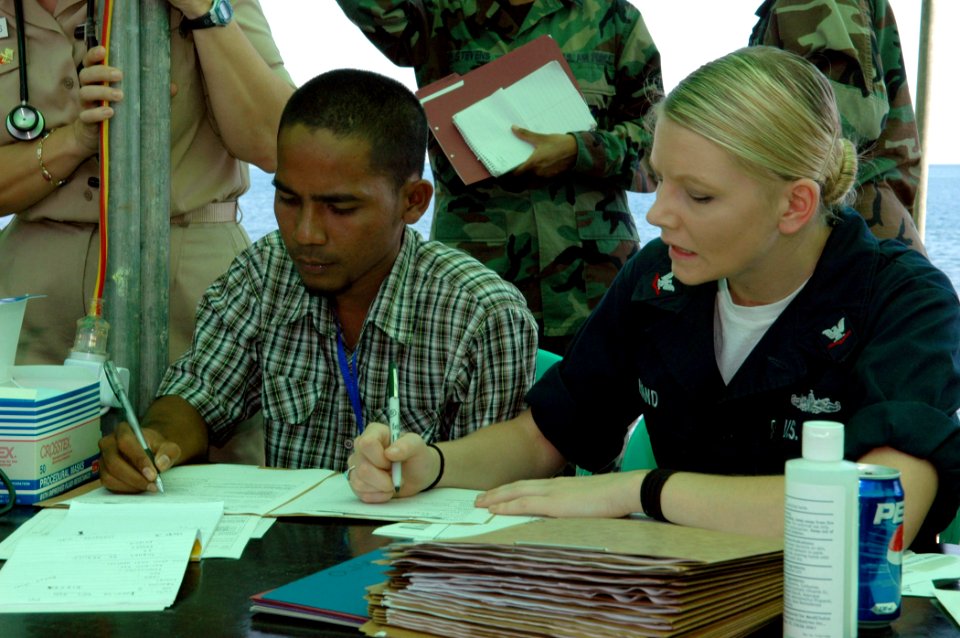 US Navy 060828-N-3714J-039 Navy Hospital Corpsman 3rd Class Brittany Hand of Conway, Ark., attached to the Medical Treatment Facility aboard the Military Sealift Command hospital ship USNS Mercy (T-AH 19), works with a transla