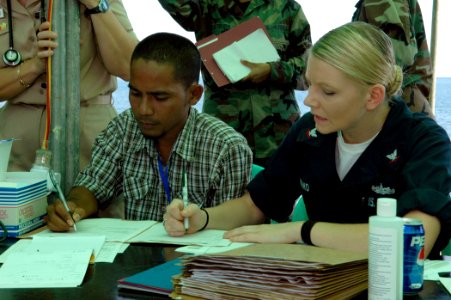 US Navy 060828-N-3714J-039 Navy Hospital Corpsman 3rd Class Brittany Hand of Conway, Ark., attached to the Medical Treatment Facility aboard the Military Sealift Command hospital ship USNS Mercy (T-AH 19), works with a transla