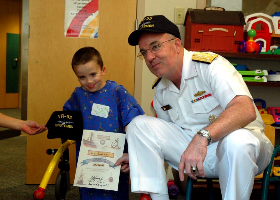 US Navy 060828-N-1805P-012 Chief of Naval Personnel, Vice Adm. John C. Harvey Jr. presents a certificate making a young child an honorary Sailor at Cleveland's Rainbow Babies and Children's Hospital