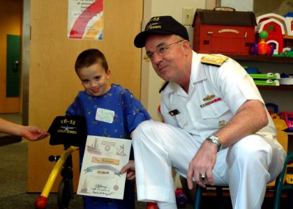 US Navy 060828-N-1805P-012 Chief of Naval Personnel, Vice Adm. John C. Harvey Jr. presents a certificate making a young child an honorary Sailor at Cleveland's Rainbow Babies and Children's Hospital
