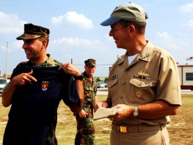 US Navy 060829-N-5758H-145 Commanding Officer of Riverine Squadron One Cmdr. William J. Guarini Jr. presents Chief of Naval Operations (CNO) Adm. Mike Mullen with a customized CNO t-shirt, during a visit of Riverine Group One (