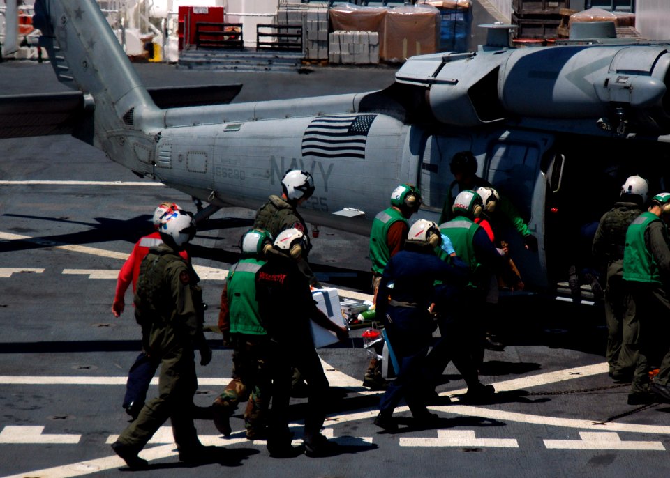 US Navy 060829-N-2832L-017 Sailors carry a patient to a waiting MH-60S Helicopter aboard the Military Sealift Command hospital ship USNS Mercy (T-AH 19)