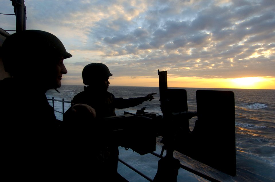 US Navy 060824-N-8604L-781 Aviation Ordnanceman 3rd Class Joshua Talley and Aviation Ordnanceman Airman Damien Sylvester man a .50-caliber machine gun on the fantail of USS Kitty Hawk (CV 63)