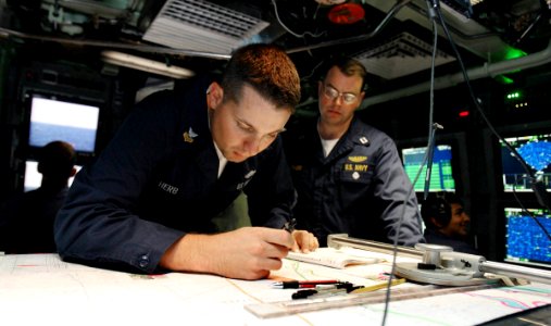 US Navy 060825-N-7441H-013 Petty 1st class Craig Herb, left, plots a course as Lt. David Leathers, right, looks on in the control room aboard the Virginia-class attack submarine USS Texas (SSN 775)