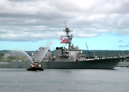 US Navy 060905-N-4965F-001 A tugboat assigned to Naval Station Pearl Harbor fires her water cannons in a traditional welcome home as the guided missile destroyer USS Russell (DDG 59) returns