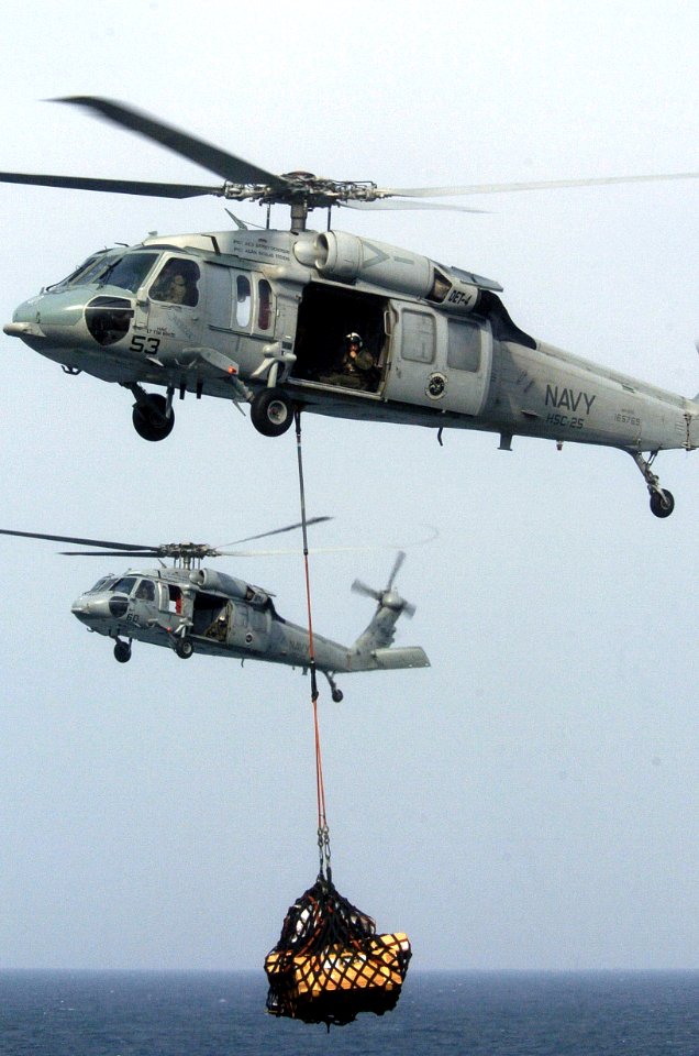 US Navy 060826-N-8604L-107 Two MH-60S Seahawks from Helicopter Sea Combat Support Squadron (HCS-25) transfers cargo from the Military Sealift Command (MSC) combat stores ship USNS Concord (T-AFS 5) to the aircraft carrier USS