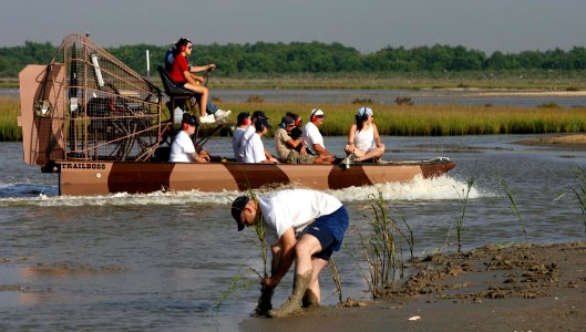 US Navy 060906-N-7441H-005 Sailors assigned to the attack submarine USS Texas (SSN 775) and marsh restoration volunteers ride a fan boat in Pierce Marsh before helping replant grasses in Hitchcock, Texas