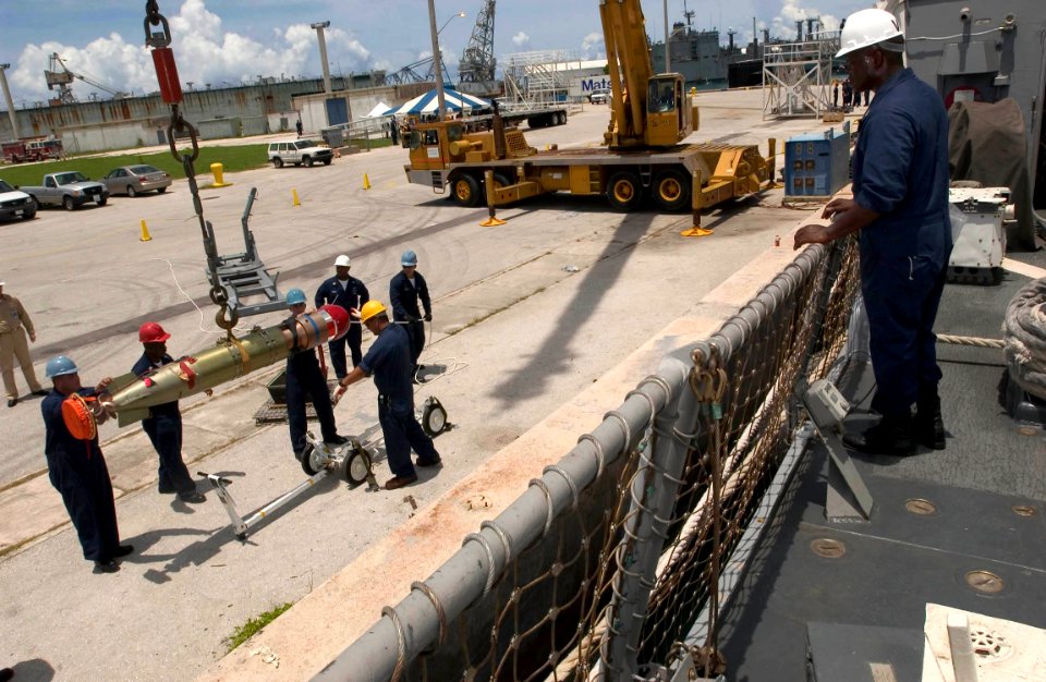 US Navy 060905-N-9851B-003 Sailors assigned to the Arleigh Burke-class guided missile destroyer USS Hopper (DDG 70) crane a torpedo to the pier during a port visit to Guam