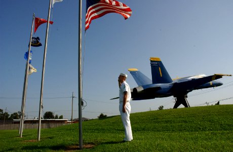 US Navy 060829-N-9458H-001 Aviation Ordnanceman Airman Aaron Stamper renders a salute to the national ensign on board Naval Air Station Joint Reserve Base, New Orleans photo