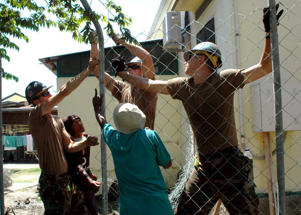 US Navy 060827-N-9076B-149 U.S. Navy Seabees assigned to the Mobile Construction Battalion (NMCB-40), deployed with the hospital ship, USNS Mercy (T-AH 19), help locals construct a fence outside Dr. Dan's Bairo Pite Clini