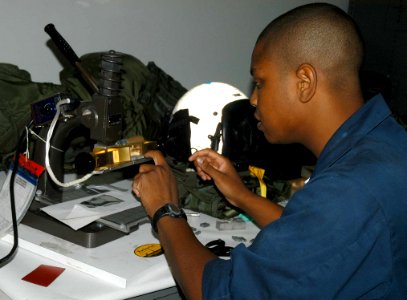 US Navy 060831-N-0068G-057 Aviation Structural Mechanic 3rd Class Joshua Graham of Atlanta, Ga., assigned to the War Eagles of Patrol Squadron Sixteen (VP-16), aligns the text lettering on the Kwik-print press