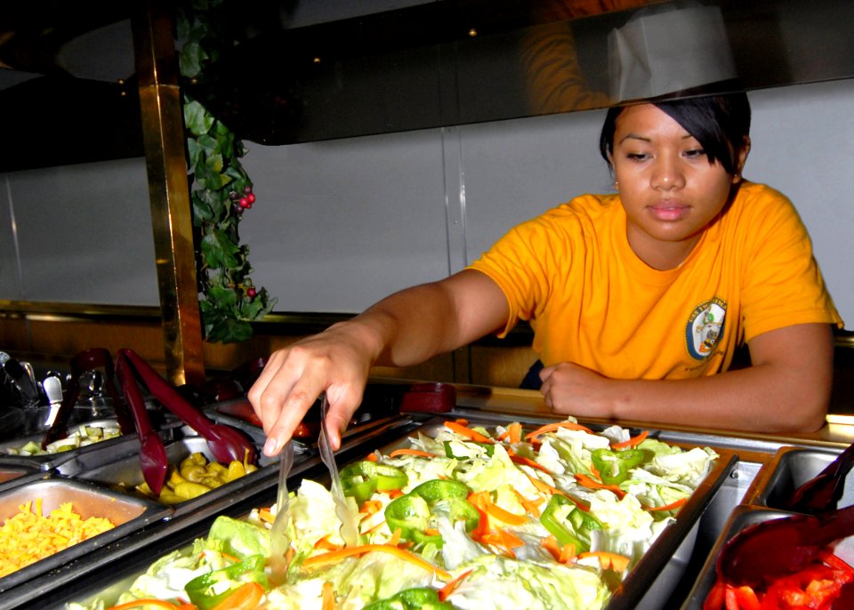 US Navy 060906-N-4856C-005 Gunner's Mate Seaman Juntine R. Velayo from Las Vegas, Nev., prepares the salad bar in the Wardroom Mess aboard the amphibious assault USS Iwo Jima (LHD 7)