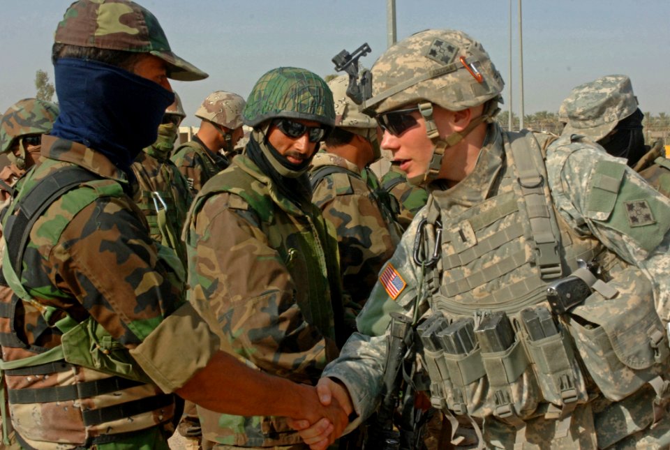 US Navy 060830-N-4097B-014 U.S. Army Lt. Alan Boyes, right, with Charlie Company, 1st Battalion, 68th Armored Regiment, 4th Infantry Division, shakes the hand of an Iraqi army soldier