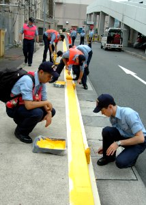 US Navy 060830-N-1332Y-045 Sailors assigned to the aircraft carrier USS Kitty Hawk (CV 63) apply fresh yellow paint to street curbs around Commander, Fleet Activities Yokosuka