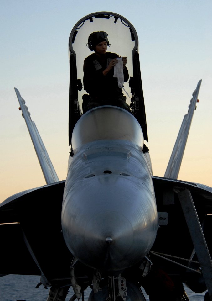 US Navy 061116-N-4776G-345 Airman Matthew Haysler wipes down the windows on the hatch of an F-A-18E Super Hornet prior to flight operations aboard USS Ronald Reagan (CVN 76)