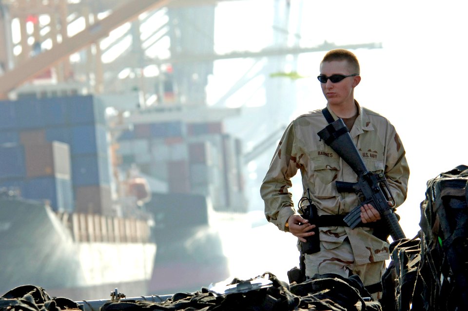 US Navy 061116-N-8148A-136 Gunner's Mate Seaman Randy Barnes, assigned to Mobile Security Squadron Three (MSS-3), closely observes activities on a pier in the port city of Jebel Ali