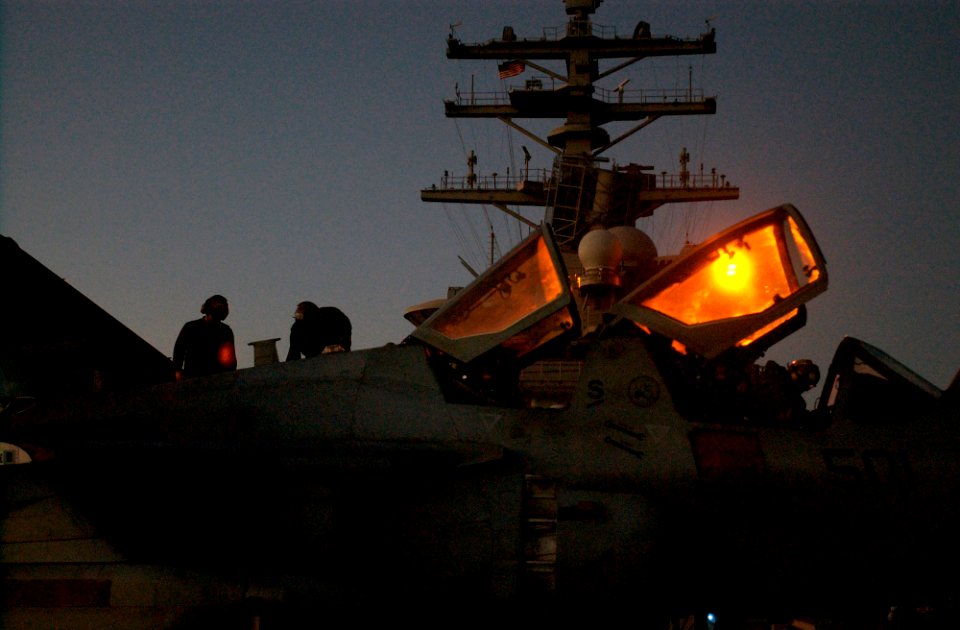 US Navy 061116-N-7130B-424 In amber light illuminating from the island of USS Ronald Reagan (CVN 76), maintenance crews assigned to the Cougars of Tactical Electronic Warfare Squadron One Three Nine (VAQ-139) prepare an EA-6B P