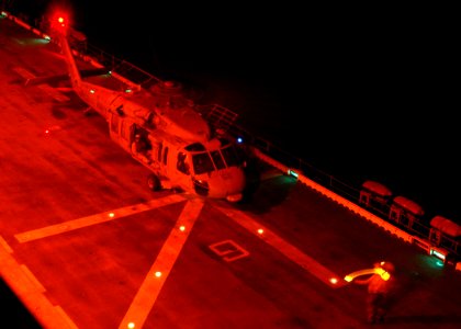 US Navy 061116-N-8547M-029 An Aviation Boatswain's Mate Handler signals to the to a flight deck member to remove chocks and chains from an MH-60S Seahawk helicopter before it is directed to lift off