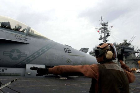 US Navy 061112-N-8591H-378 Aviation Structural Mechanic Airman Jyoteendra Singh assigned to Strike Fighter Squadron Two Seven (VFA-27) signals the pilot of an F-A-18E Super Hornet to start his engines on the flight deck of USS