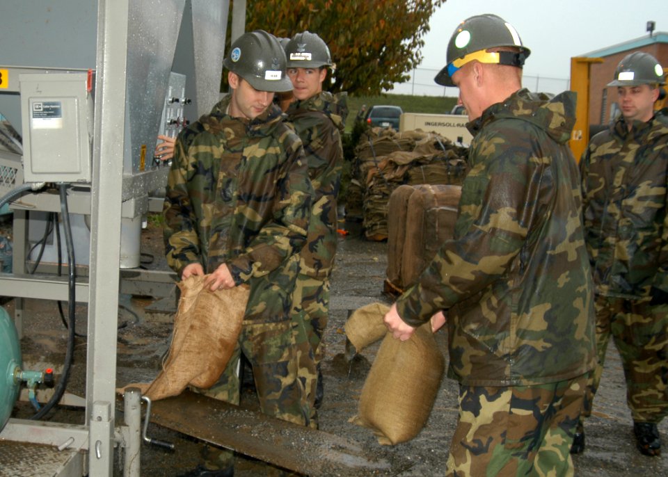 US Navy 061107-N-6247M-004 Builder 1st Class Steve Peck, from Vancouver, Wash.,left, and Builder 1st Class Dirk Wehking, from Fulda, Minn., right, prepare sand bags to help construct a dike in front of the City of Anacortes Wat