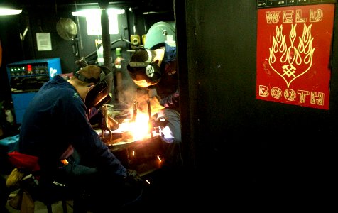 US Navy 061110-N-7130B-112 In the weld booth aboard USS Ronald Reagan (CVN 76), Sailors fabricate support stands using raw materials