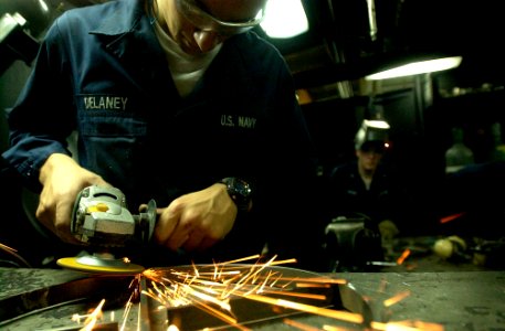 US Navy 061110-N-7130B-181 Hull Maintenance Technician Fireman Sam Delaney from Wellington, Colo., uses a grinder to smooth the weld on a freshly fabricated support stand in the weld booth on board USS Ronald Reagan (CVN 76)