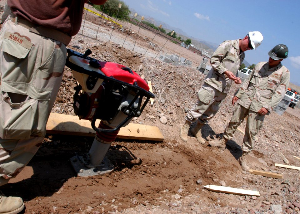 US Navy 061109-N-1328C-075 Commander 1st Naval Construction Division, Rear Adm. Robert Phillips (Right), discusses dirt samples with Steel Worker 1st Class Dennis Ryan, and a member of Naval Mobile Construction Battalion Five (