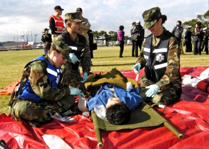 US Navy 061115-N-4649C-089 Doctors and hospital corpsmen from U.S. Naval Hospital Yokosuka, Japan Special Medical Operation Response Team (SMORT), assist a patient during a mass casualty drill held at the Hakozaki Fuel Terminal