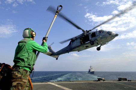 US Navy 061120-N-8148A-033 U.S. Navy Airman Charles Robinson, assigned to the Dragon Whales of Helicopter Sea Combat Squadron Two Eight (HCS-28), prepares to attach a pendant to an MH-60S Seahawk helicopter
