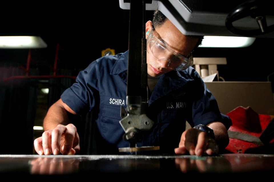US Navy 061120-N-1332Y-103 Aviation Structural Mechanic Airman Cesar Schira, from New York City, uses a band saw to fabricate a shelf in the airframes shop on board USS Kitty Hawk (CV 63)