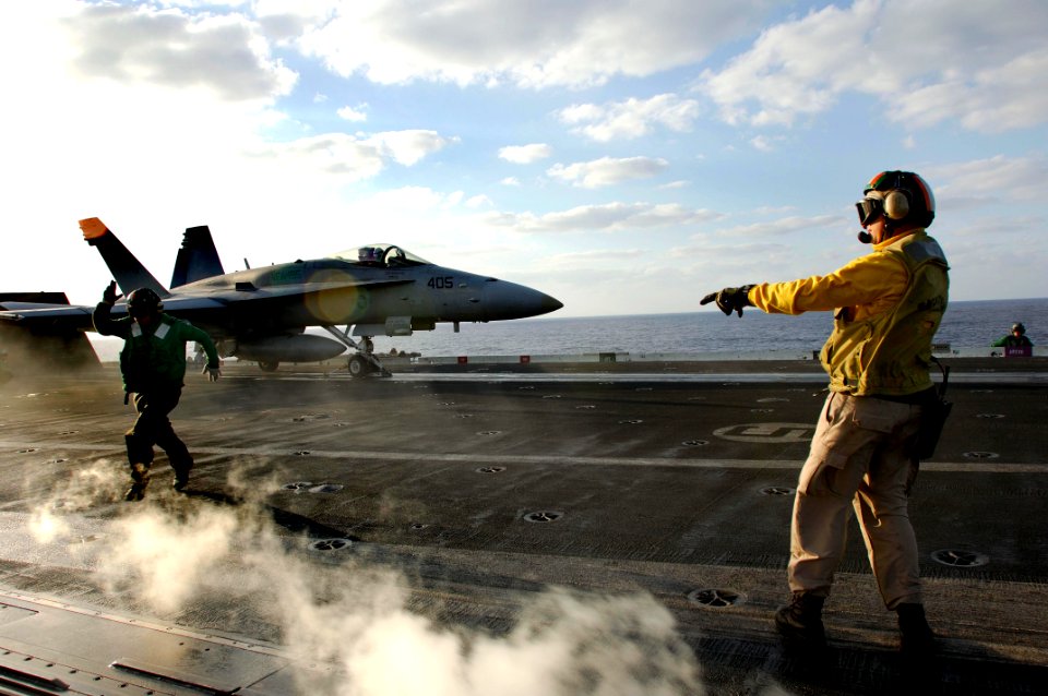 US Navy 061113-N-8591H-167 Chief Aviation Boatswain's Mate Marshall Townsend ensures an F-A-18C Hornet is cleared for launch from the flight deck aboard USS Kitty Hawk (CV 63)