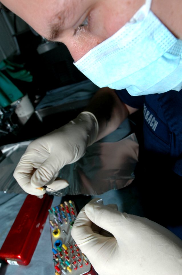 US Navy 061118-N-2659P-032 U.S. Navy Hospital Corpsman Roger Seebach inspects tools while preparing for routine dental treatments aboard the nuclear-powered aircraft carrier USS John C. Stennis (CVN 74)